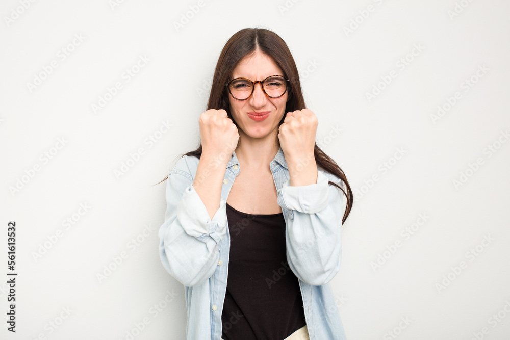 Young caucasian woman isolated on white background showing fist to camera, aggressive facial expression.