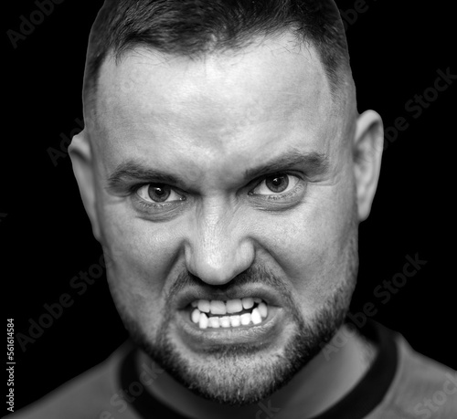 Portrait of a furious man on a black background.