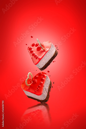 Red glazed levitating cheese cake in the shape of a heart with fruit jelly decoration. Exquisite Fresh delicious mousse floating dessert. photo