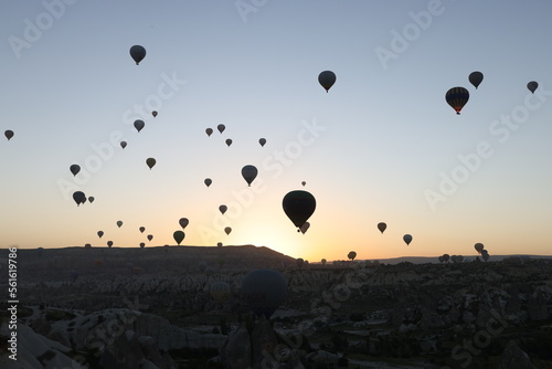 Many hot air balloons flying in sunset sky at Cappadocia, Turkey.