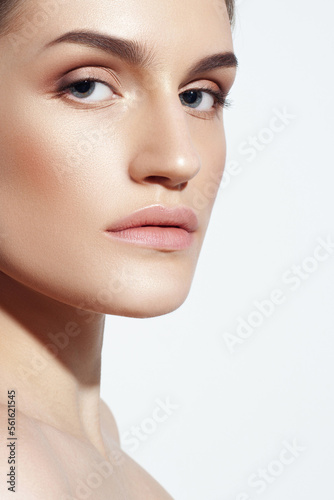 Young Caucasian girl with perfect glowing skin and natural makeup in close-up