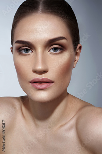 Beautiful caucasian girl with perfect skin and natural makeup on gray background