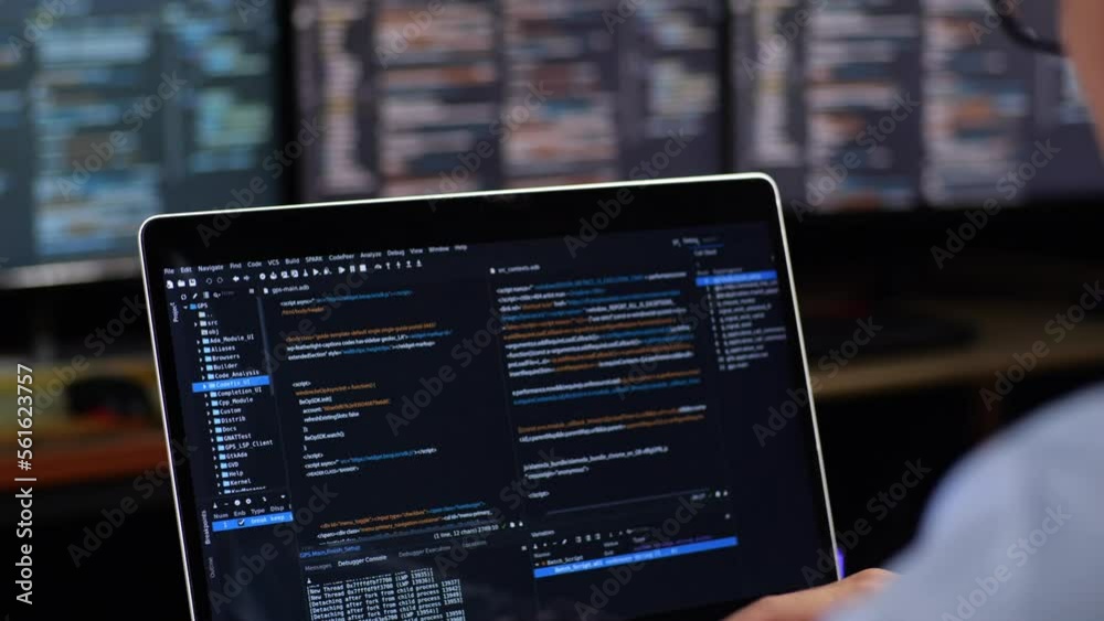 Close Up Of A Laptop'S Monitor Showing Database Being Written By A Male With Multiple Monitors Desktops. Programmer Writing Code In The Office
