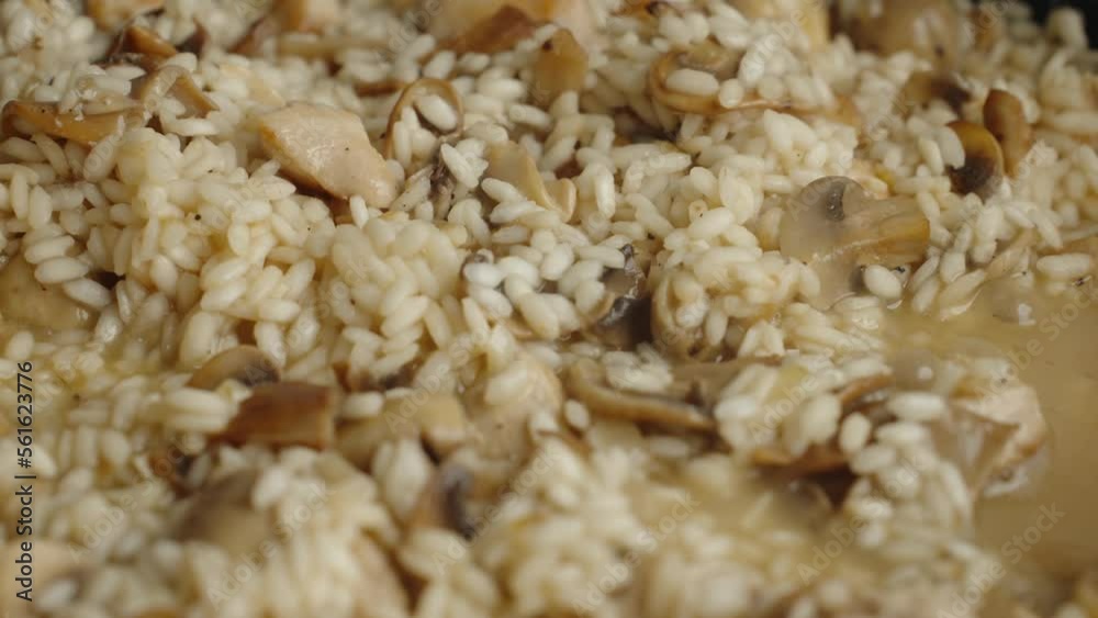 Process of cooking risotto with mushrooms. Arborio rice boiled in frying pan in home kitchen, close up. Italian cuisine dish Process of cooking risotto with mushrooms. Arborio rice boiled in frying pan in home kitchen, close up. Italian cuisine dish