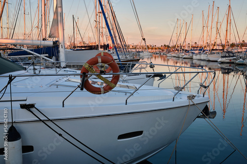 Yacht parking in the marina at sunset. Sea bay with yachts at sunset. Moored yachts. Marina, port. reflection of boat masts in sea water at sunset. Torrevieja, Alicante, Spain
