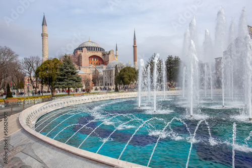 Amazing landscape with shiny sun in sky and splash of water in fountain and Blue Mosque in background