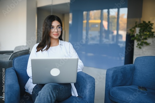 Beautiful Caucasian woman dreaming about something while sitting with portable net-book in modern cafe bar, young charming female freelancer thinking about new ideas during work on laptop computer