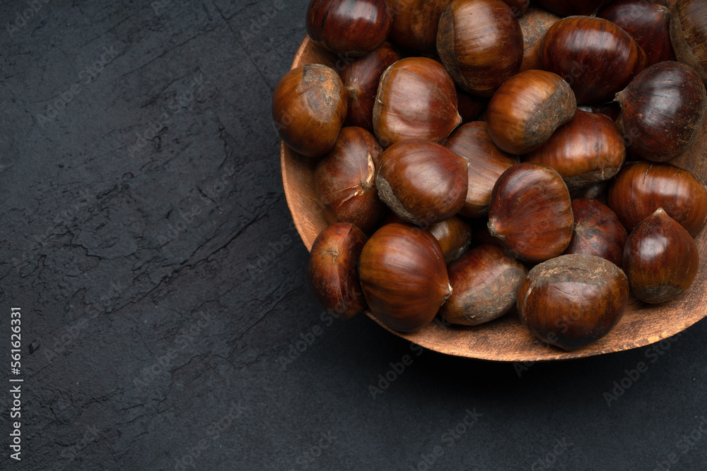 Raw roasted chestnuts on black background Raw roasted chestnuts on black background