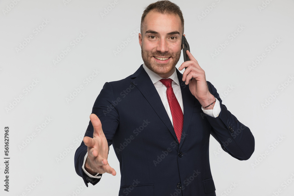 Naklejka premium happy elegant man having a phone call and making a hand gesture