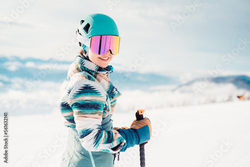 Fotografia Woman in skiing clothes with helmet and ski googles on her head with ski sticks