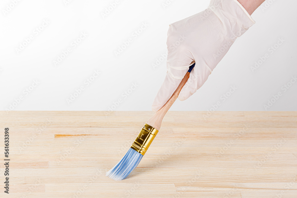 painting wooden background, hand with brush and can of paint