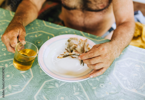 Adult man drinks beer and eats dry fish while sitting in a bar in summer. Food photography.