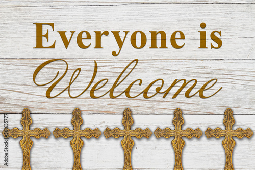 Everyone is welcome message with bronze religious cross on wood photo