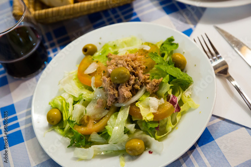 Ensalada manchega, traditional spanish salad with greens, tomatoes, olives and canned tuna