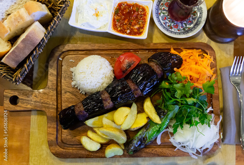 Traditional Turkish Patlicanli kebap from pieces of eggplant and minced lamb meat served with vegetables and rice photo