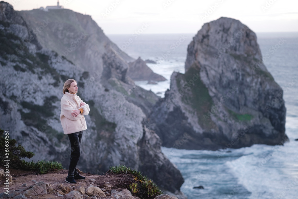 Woman stands on the Atlantic cliffs near Cape Roca, Portugal.