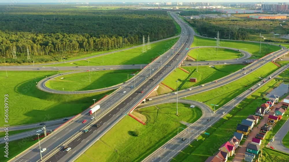 Aerial view of highway interchange. Road junction in the suburbs around meadows and forest Aerial view of highway interchange. Road junction in the suburbs around meadows and forest