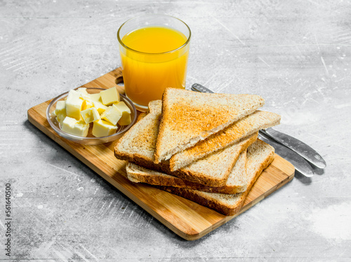 Breakfast. Toasted bread with butter and a glass of orange juice. photo