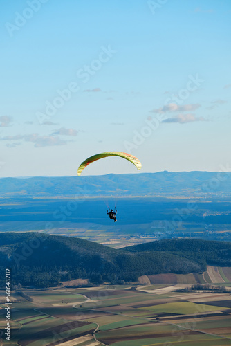 paraglider in the sky over the sun-drenched austrian valley