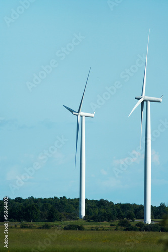 windmills stand against a blue cloudy sky