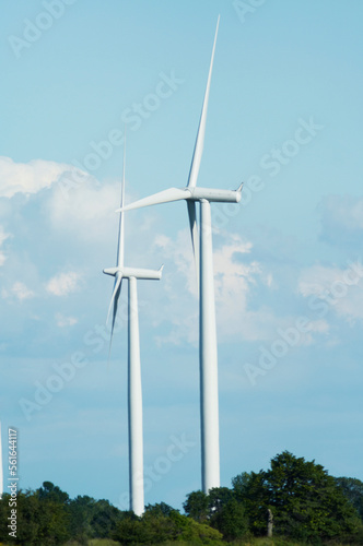 windmills stand against a blue cloudy sky
