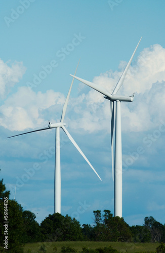 windmills stand against a blue cloudy sky