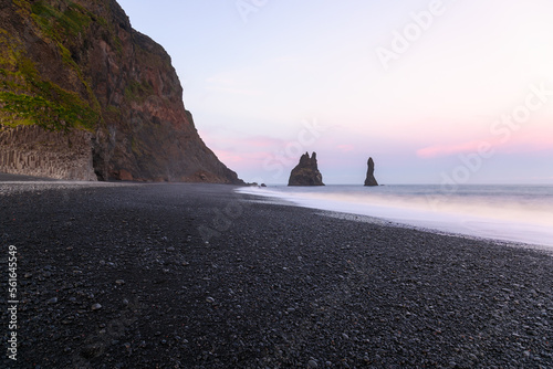 Sea stacks along a black pebble beach in Iceland under midnight sun in summer