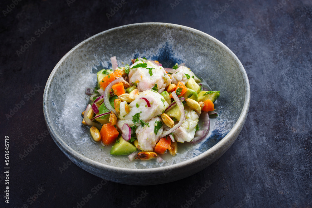 Traditional Peruvian gourmet ceviche sea bass filet piece with sweet potatoes and cancha marinated and served in lime sauce as close-up in a Nordic design bowl Traditional Peruvian gourmet ceviche sea bass filet piece with sweet potatoes and cancha marinated and served in lime sauce as close-up in a Nordic design bowl
