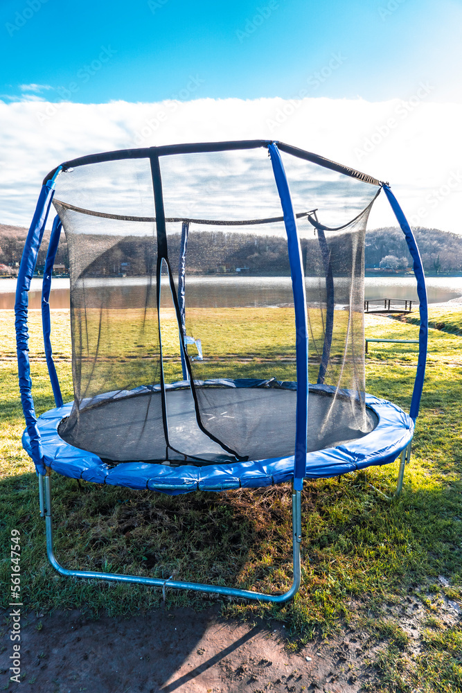 Empty trampoline on the beach by the lake after the summer season Empty trampoline on the beach by the lake after the summer season