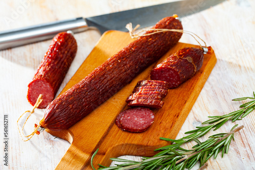 Close-up of smoked russian sausage at wooden surface, nobody photo