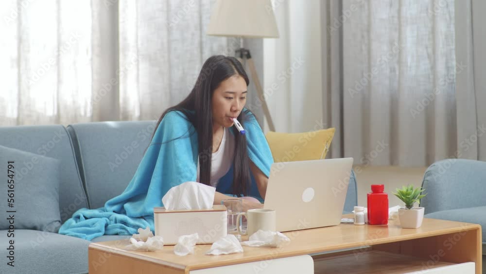 Asian Woman With Blanket Using Thermometer Test For Flu, Cold And Body Temperature While Sitting On Sofa Works On A Laptop Computer In The Living Room At Home
Asian Woman With Blanket Using Thermometer Test For Flu, Cold And Body Temperature While Sitting On Sofa Works On A Laptop Computer In The Living Room At Home