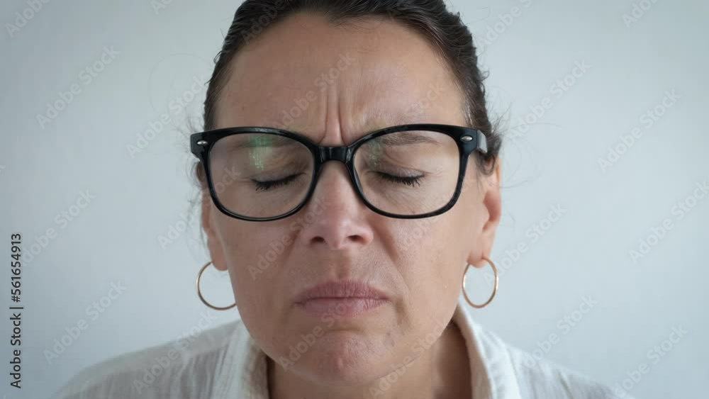 Troubles from eyes strain in glasses indoor. A sad good looking female suffering from eyes strain and use glasses in the room. Troubles from eyes strain in glasses indoor. A sad good looking female suffering from eyes strain and use glasses in the room.
