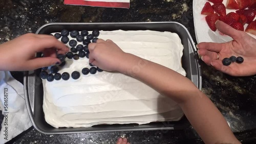Making 4th of July Cake with blueberries and strawberries