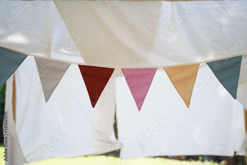Colorful triangle flags decorate in garden. Outdoor party concept.