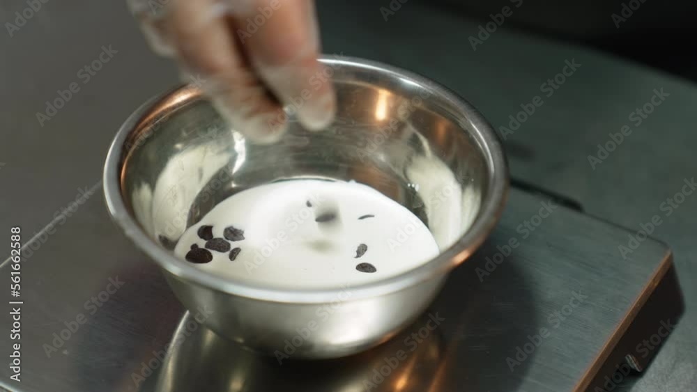 Pastries in making. Person weighing chocolate chips in a meal bowl. High angle shot. High quality 4k footage