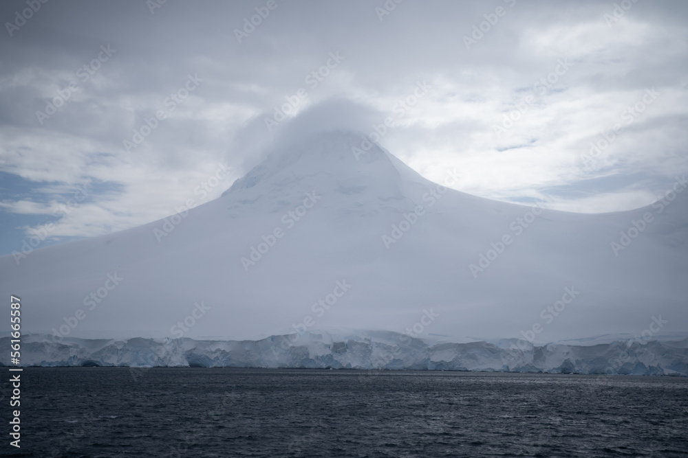 snowy mountain in antarctica with a cloud hat