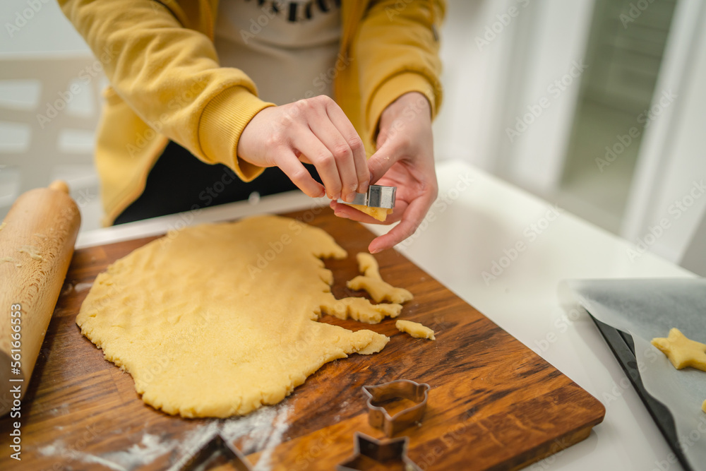 Top and side view of mother and daughter preparing gingerbread cookies with rolling pin in their kitchen in different shapes heart and stars Top and side view of mother and daughter preparing gingerbread cookies with rolling pin in their kitchen in different shapes heart and stars
