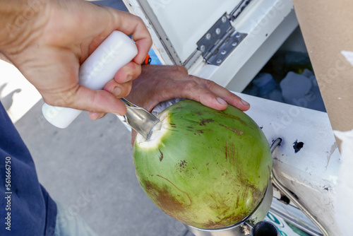 Street seller opens coconut to extract water. Salvador, Bahia state, Brazil photo