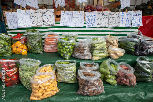 Packets of various types of vegetables and tubers in the wholesale market stall. Names of vegetables in portuguese photo
