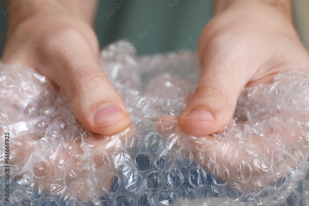 Man popping bubble wrap, closeup view. Stress relief Man popping bubble wrap, closeup view. Stress relief
