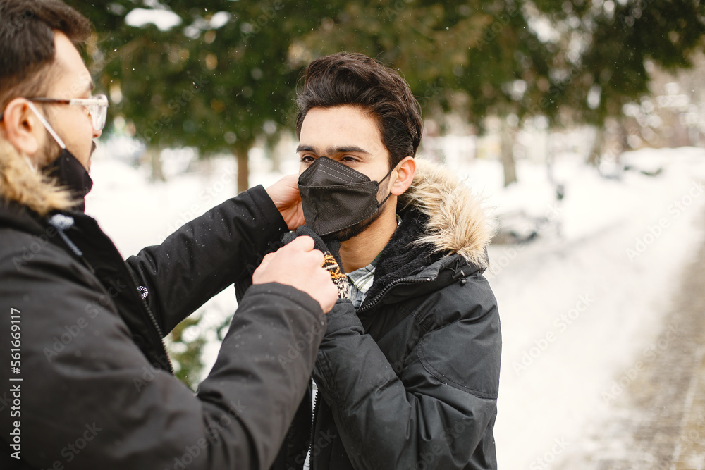 Indian boys stand on street in winter in masks Indian boys stand on street in winter in masks