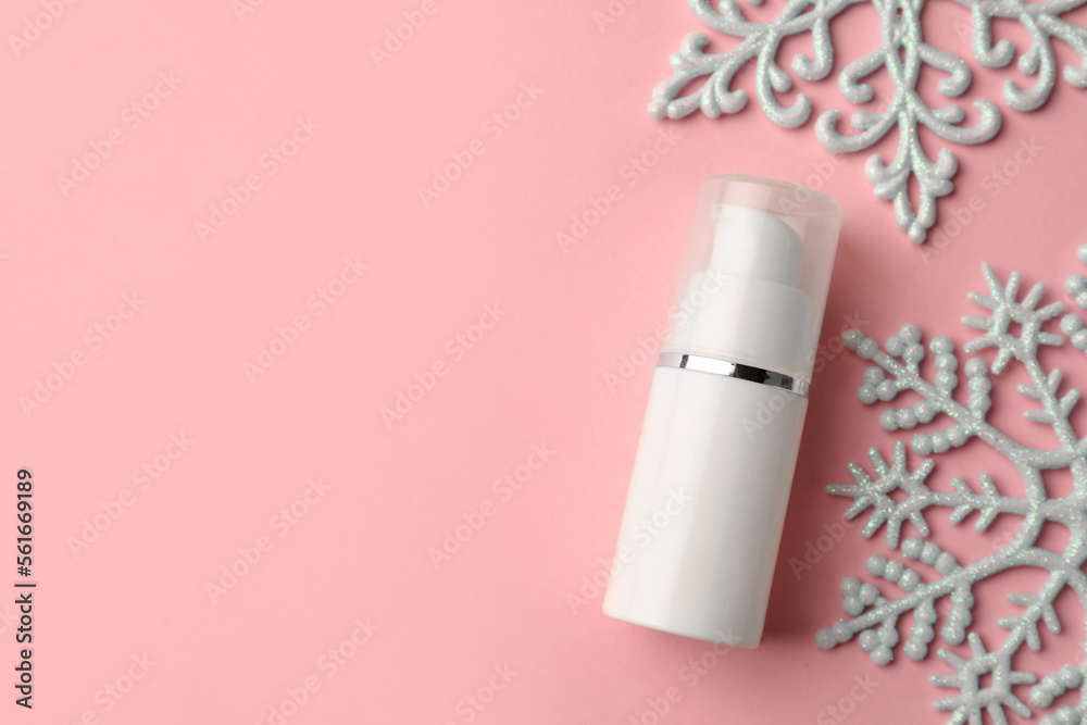 Winter skin care. Hand cream near snowflakes on pink background, flat lay. Space for text Winter skin care. Hand cream near snowflakes on pink background, flat lay. Space for text