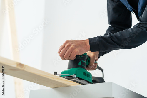 電動ヤスリで木材を研磨する男性　大工　DIY photo