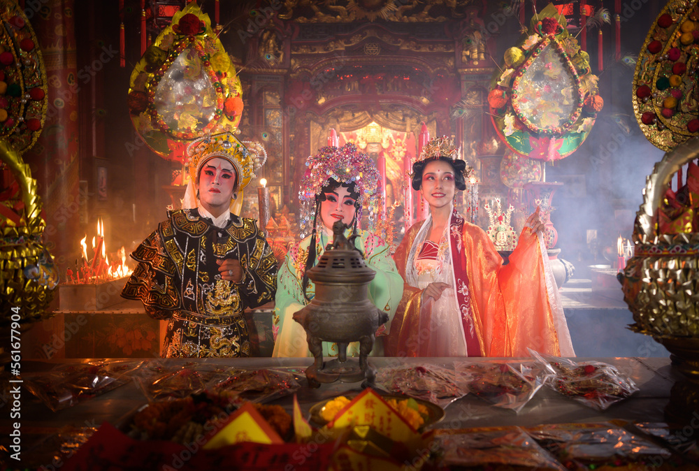 Male and female Chinese opera actors Light a candle to pray homage to the gods to enhance the prosperity for yourself on the occasion