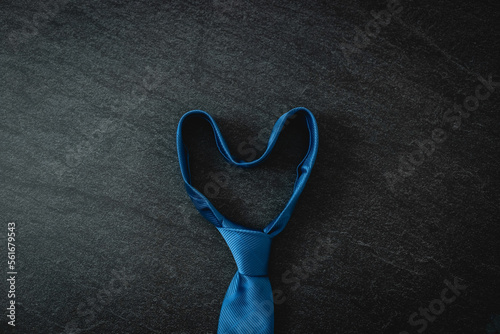 One blue tie on a black stone background.