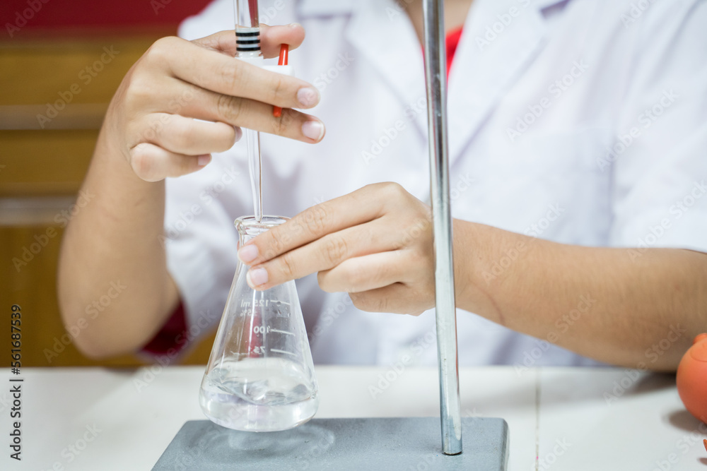 Fototapeta premium Close up student doing a chemical experiment in laboratory at the elementary school. Education concept.