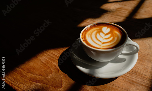 Cup of hot latte art coffee on the wooden table. morning drink concept