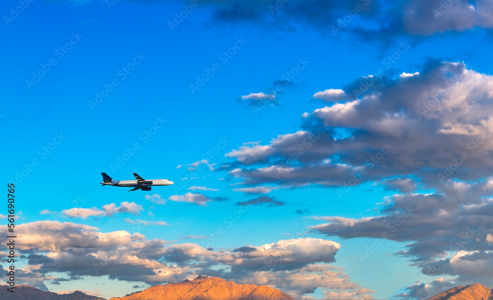 Naklejka premium Airplane flying over the mountains and clouds