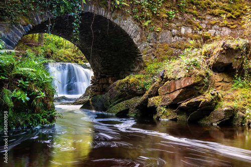 Torc Waterfall flowing under a bridge in Killarney National Park, Ireland