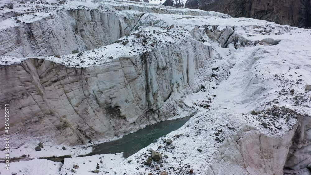 Rotating revealing drone shot of a large opening and ravine in the Ak-Sai glacier in Kyrgyzstan Rotating revealing drone shot of a large opening and ravine in the Ak-Sai glacier in Kyrgyzstan